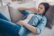 Portrait of stressed depressed woman lying on sofa bite her teeth suffer from terrible stomachache pms needs ambulance wear denim jeans outfit in room