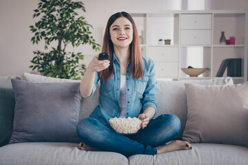 Sticker - Photo of amazing lady going to watch favorite humor tv show holding popcorn plate on crossed legs sitting comfy sofa wearing jeans clothes apartment indoors