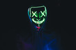 © godbamn - Portrait of young male wearing hoodie and green led light mask in the darkness