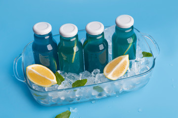 Wall Mural - Close up of blue detox water in glass bottle with lemon slices