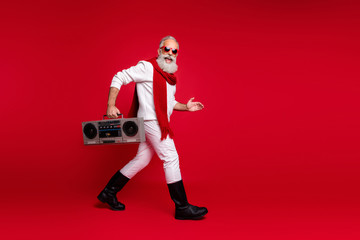 Full body profile side photo of excited grandfather going holding audio cassette wearing white sweater isolated over red background