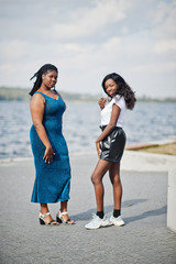 Two african american dark skinned friends female. One of them plus size model, second slim. Having fun and spending time together.