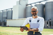 © cherryandbees - agricultural worker using tablet in front of grain silos