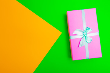 Wall Mural - gift box with ribbon on a colorful background. view from above.