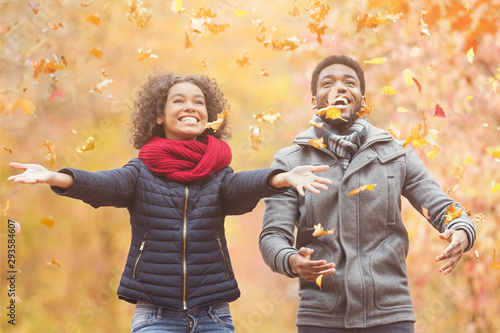 Happy afro couple throwing autumn fall leaves Tableau sur Toile