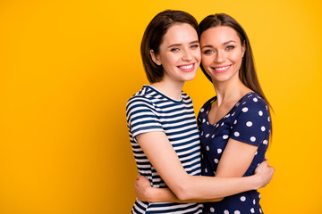 Sticker - Mother's daughters. Photo of two amazing ladies hugging best sisters relatives wear summer casual trendy dresses isolated yellow background