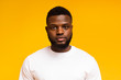© Prostock-studio - Serious young african american man portrait on yellow background