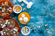 Halloween Sweets And Treats - Skull Cookies, Candy Corn, Pumpkin Panna Cotta, Meringue Bones Top View