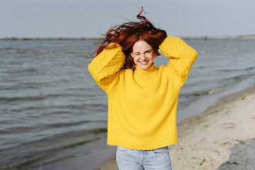 Happy carefree woman with her hands to her hair