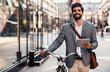 Smiling businessman using tablet on the way to office. Business, education, lifestyle concept