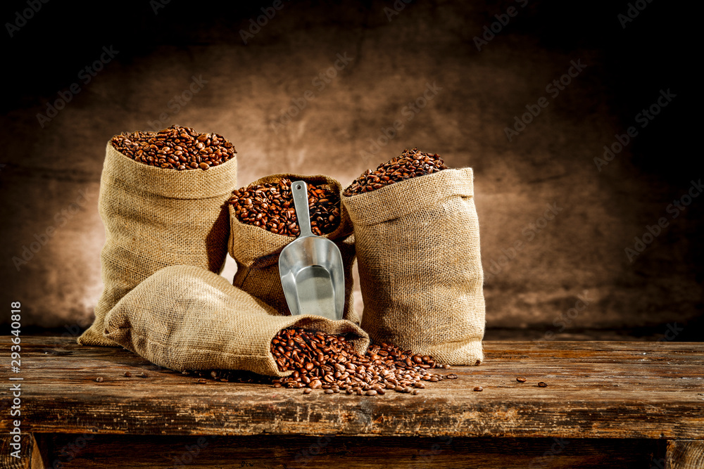 Fresh old sack of coffee grains and brown old wall background  - obrazy, fototapety, plakaty 