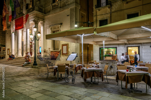 Street with bridge and tables of restaurant in Venice, Italy. Architecture an...