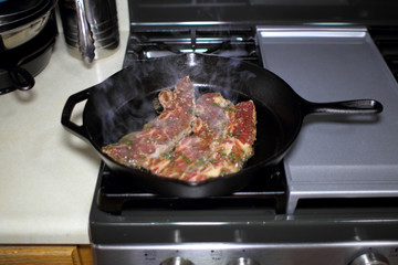 Wall Mural - Korean style BBQ short ribs, known as Kalbi, on a cast iron skillet in a home kitchen.