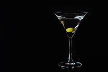 Martini Glass And Olives On A Black Background. Selective Focus. Close Up.