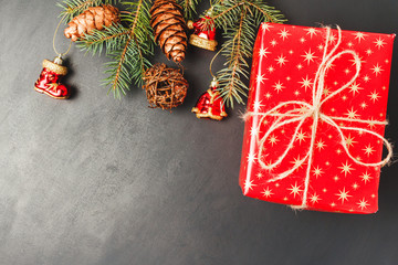 Christmas or New Year background with decorations, pine branch and red gift box, top view with copy space