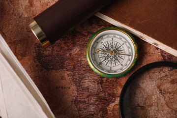 Sticker - top view of compass near copy book and magnifying glass on old world map