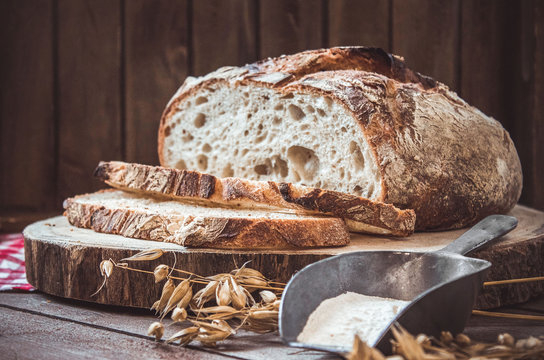 Geschnittenes Brot auf einem Holzbrett mit Zutaten