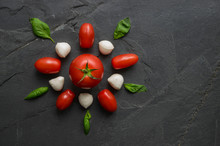 Traditional Italian Pizza Ingredients From Above In Flower Shape On Dark Slate Background