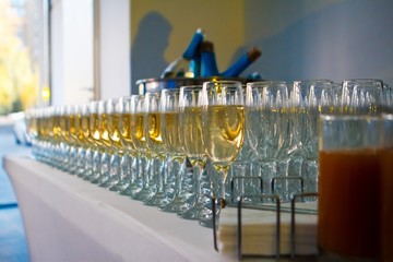 aperitif set with rows of alcohol glasses filled with dry white wine, restaurant catering at a party