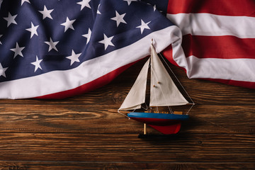 Sticker - top view of leather crafted ship on wooden surface with American national flag