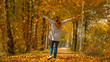 © helivideo - Unrecognizable girl outstretches arms after throwing a pile of dry leaves in air