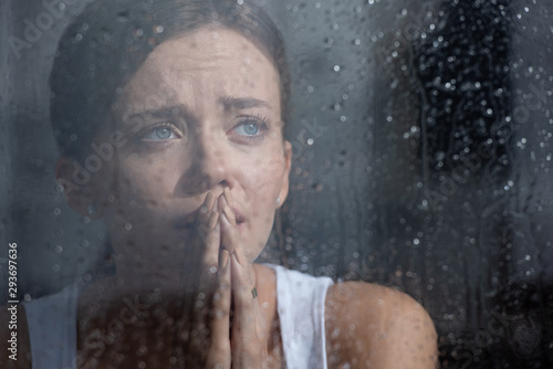 Fotografía selective focus of upset young woman crying and showing please gesture at home