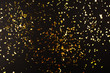 Leinwandbild Motiv Gold foil confetti on black background. Flatlay.