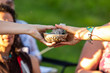 Sacred drums during spiritual singing. A close up view on the hands of two spiritual people, passing sacred objects during an outdoor meeting celebrating native culture and tradition.