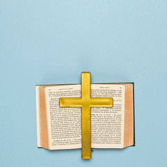 Holy book opened with wooden cross