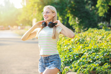 Sticker - Beautiful young woman with headphones outdoors