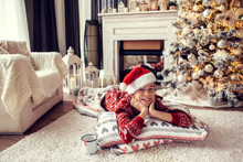 Child Relaxing By Christmas Tree At Home