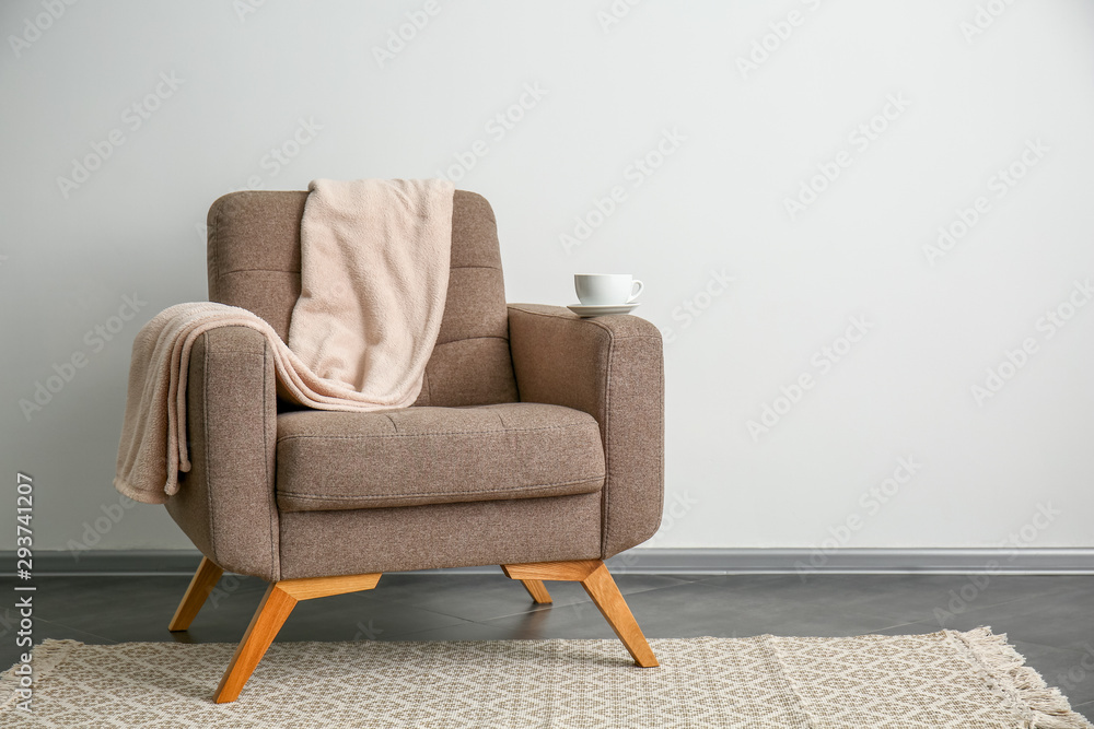 Comfortable armchair near light wall
