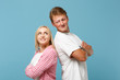 © ViDi Studio - Young couple two friends guy girl in white pink empty blank design t-shirts posing isolated on pastel blue background studio portrait. People lifestyle concept. Mock up copy space. Looking each other.