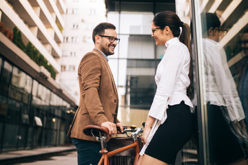 Wall Mural - Office woman with business man couple enjoying break while talking flirting outdoor