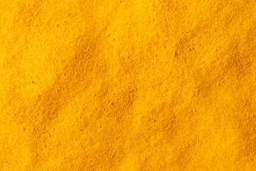 Turmeric powder texture. Background with copyspace. Close up. Top view