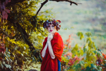 Sensual woman in wreath over the autumnal tree