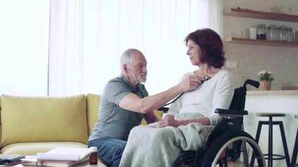 Wall Mural - Health visitor and a senior woman with wheelchair during home visit.