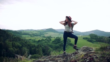 Wall Mural - young tourist woman traveller with backpack standing in nature.