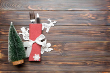 Top View Of Fork And Knife Tied Up With Ribbon On Napkin On Wooden Background. Christmas Decorations And New Year Tree. Happy Holiday Concept With Empty Space For Your Design