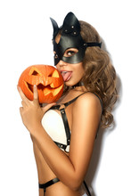 Sexy Girl With Halloween Pumpkin In Black Leather Cat Mask On White Isolated Background