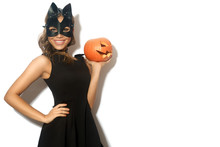 Happy Young Women In Little Black Dress With Halloween Pumpkin And In Cat Mask Over White Background