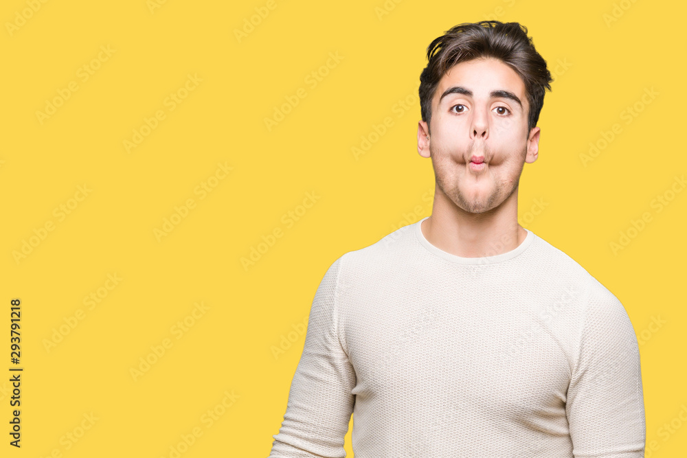 Young handsome man over isolated background making fish face with lips, crazy and comical gesture. Funny expression.