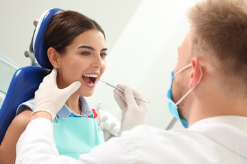 Wall Mural - Professional dentist working with patient in clinic