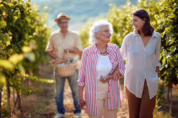 Wall Mural - Wine and grapes. Family tradition. Harvesting grapes. mother and daughter on autumn vineyard .