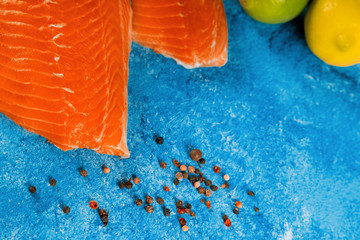 Wall Mural - Salmon, Red fish fillet on tray with lemon and spices on background, top view