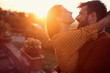 © luckybusiness - Smiling couple hugging and kissing at sunset.