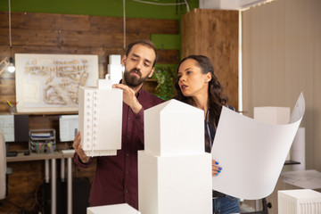 Caucasian team of creative designers working on 3D models of buildings