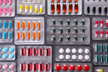 Flat Lay Composition With Bunch Of Different Colorful Pills In Blister Packs. Pile Of Unpacked Medication On Paper Textured Background. Close Up, Copy Space.