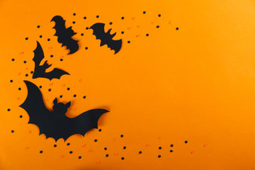 Wall Mural - Halloween themed flat lay composition with decorative bats, on dark paper textured background with a lot of space for text. Close up, top view.