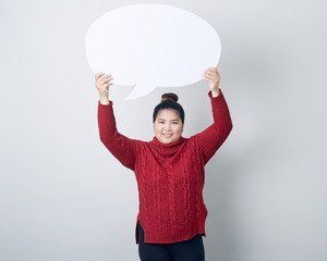 woman in sweater holding empty speech bubble